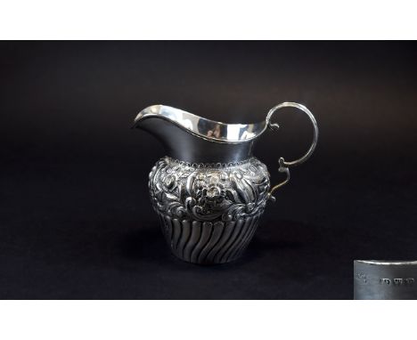 Victorian Ornately Decorated Helmet Shaped Silver Milk Jug with Half Fluted Body and Embossed Floral Decoration Above Scroll 