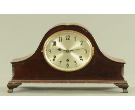 An early 20th century mahogany mantle clock, having an oval dial with three train movement, all supported upon short bracket 