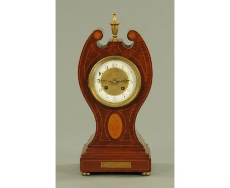 An Art Nouveau mahogany and inlaid mantle clock, late 19th century, with brass urn finial above the enamelled dial with Arabi