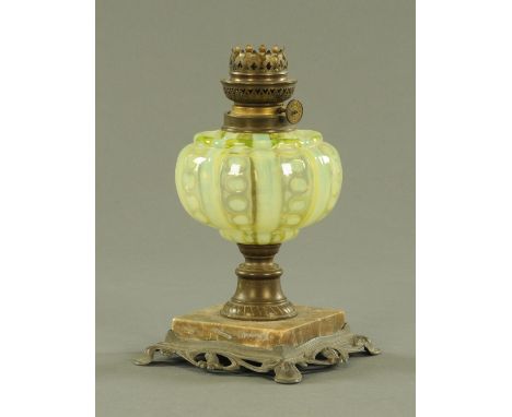 A French Art Nouveau oil lamp, with vaseline glass reservoir upon an onyx base in turn above an Art Nouveau sinuous metal foo