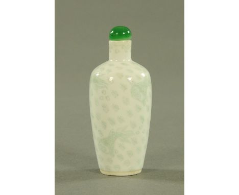 A Chinese porcelain snuff bottle, mid 20th century, the body with incised decoration of carp amongst reeds heightened in gree