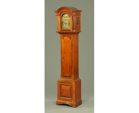 An early 20th century walnut grandmother clock, having a domed hood above an arched brass dial with Roman and Arabic numerals