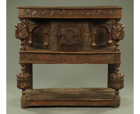 A 17th century and later inlaid court cupboard, with undulating frieze carved with florets and foliage, supported on bulbous 