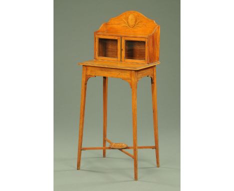 An Edwardian satinwood side cabinet, with rear upstand and pair of glazed cupboard doors all raised on tapered legs of square