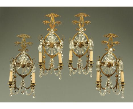 A set of four early 20th century gilt metal two branch side light brackets, in the Classical style, with ribbons, swags and b