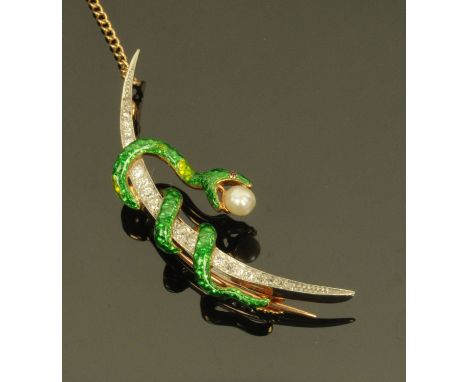 A diamond set crescent shape brooch, 20th century, the crescent entwined by a green enamel snake biting a seed pearl, on whit