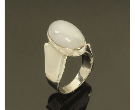 A Chinese 18 ct white gold ring, stamped "18 K", set with a light grey jade cabochon, size L, 8 grams. 