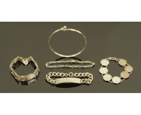 A silver gate bracelet, a silver identity bracelet, a planished silver bangle, a silver threepence bracelet and a further sil