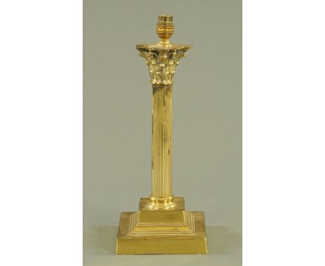 A brass table lamp, 20th century, with Corinthian capitol and fluted column upon a square stepped base.  Height excluding lig