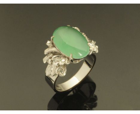 A Chinese 18 ct gold ring, set with an oval jade stone, the mounts to simulate diamonds, stamped "18 K", size L, 5.9 grams.  