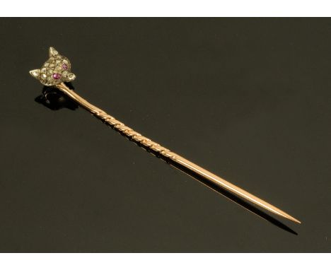 A diamond and ruby encrusted fox head stick pin, on gold coloured metal shaft.  5.5 cm. 