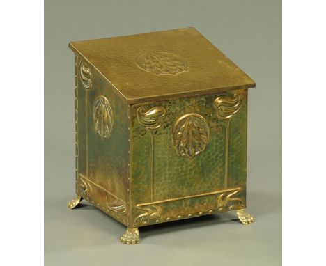 An Art Nouveau planished brass coal receiver, having a sloping top with embossed olive leaf decoration, the front with simila