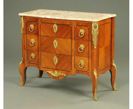A French marble topped three drawer commode, early 20th century, with gilt metal mounts, cast bellflower ring handles and roc