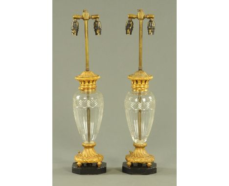 A pair of cut and faceted glass table lamps, with gilt metal mounts and raised on octagonal marble bases.  Height including l