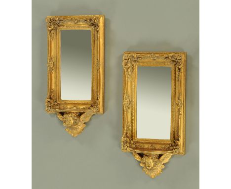 A pair of Victorian style moulded and gilt mirrors, 20th century, each with rectangular bevelled glass in an ornate moulded f