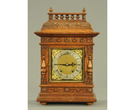 A late Victorian oak mantle clock, having a carved gallery pediment and rosette bosses above the square brass dial marked "P.