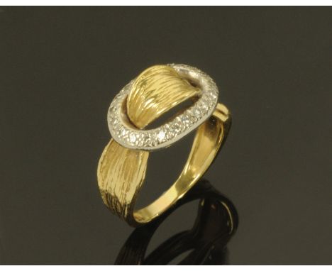 A ladies buckle type ring, the white metal buckle inset with small diamonds on a yellow metal sash type shank, size J/K.