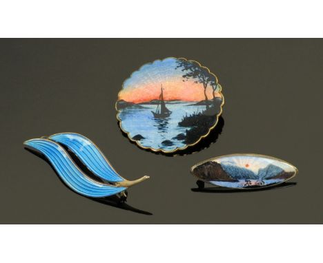 Three Aksel Holmsen Norwegian silver and enamel brooches, two decorated with landscapes the other as two leaves.