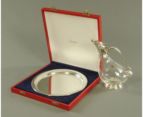 A Cartier polished pewter circular salver with raised sides, diameter 27.7 cm, with fitted Cartier presentation case and a mo