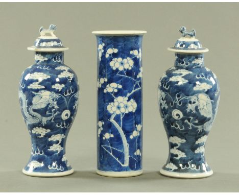 A pair of Chinese blue and white vases and covers, late 19th century, the covers with dog of fo finials, the vases decorated 