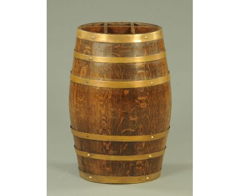 A 19th century oak and brass coopered stick stand, of oval form with sectioned top and interior drip tray.  62 cm high.