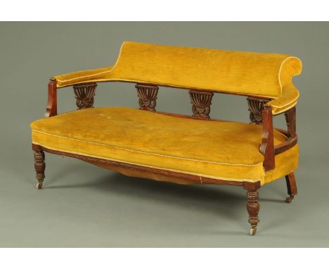 An Edwardian walnut and yellow cloth upholstered settee, with carved and pierced back supports, all upon turned legs with cer