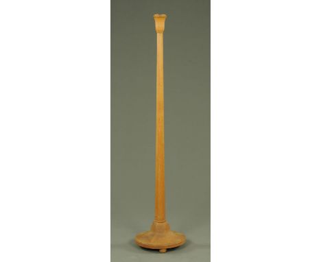 An Art Deco period golden oak standard lamp, with tulip shaped terminal above an inverted tapering hexagonal body upon a spre