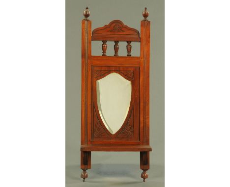 An Edwardian walnut framed mirror with shelf, the plate shield shaped and bevelled.  Width 27 cm.