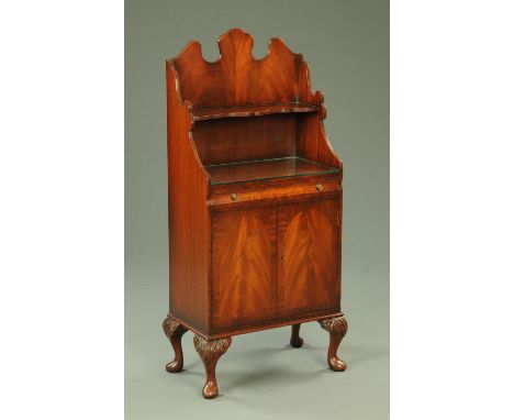 A mahogany side cabinet, with shaped pediment, shelf, single drawer above a pair of panelled cupboard doors and raised on cab