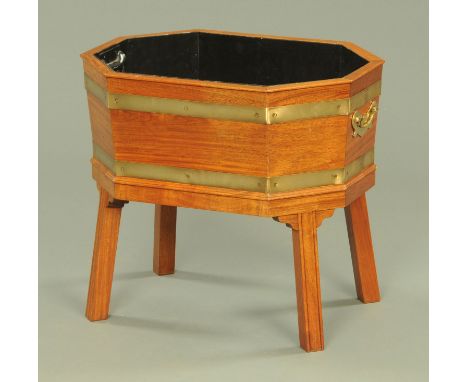 A George III style brass bound octagonal planter, with interior liner, supported upon four channel moulded legs, brass carryi