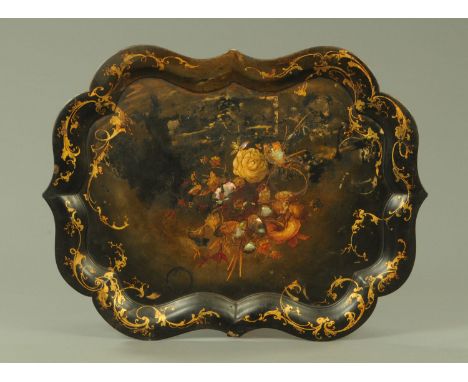 A 19th century papier mache tray, of shaped outline decorated with gilt scrolls and inlaid with mother of pearl.  Length 81 c