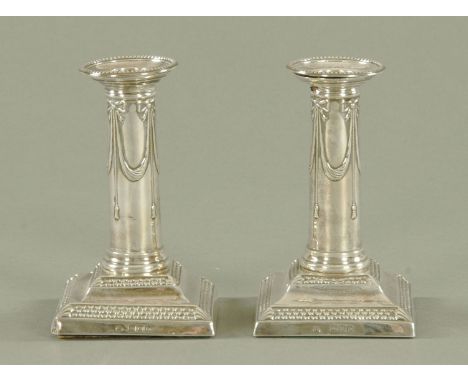 A pair of late Victorian silver candlesticks, maker Thomas Bradbury & Sons, with detachable sconces and decorated with ribbon