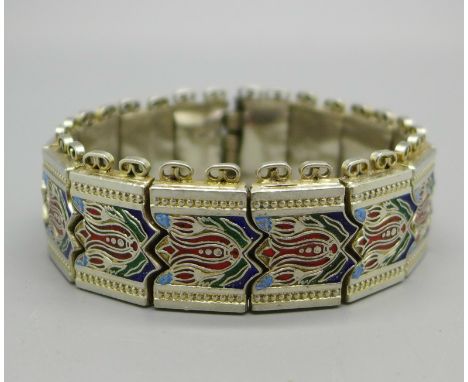 A white metal and enamel bracelet, each panel marked 84N.U, 73g 
