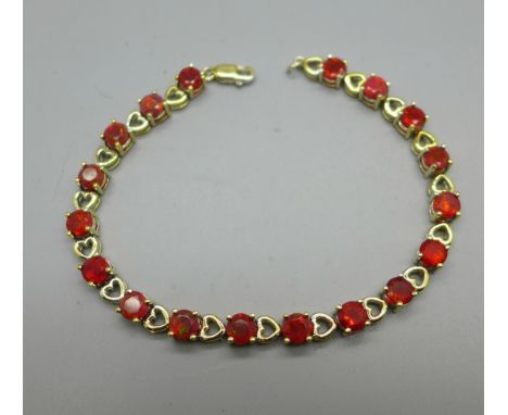 A silver gilt and eighteen fire opal line bracelet 