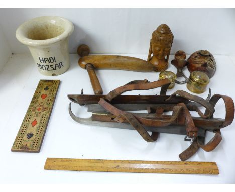 A pair of speed skates, a wooden cribbage board, wooden small mask and figure, a set of brass trinket pots, a bottle opener, 