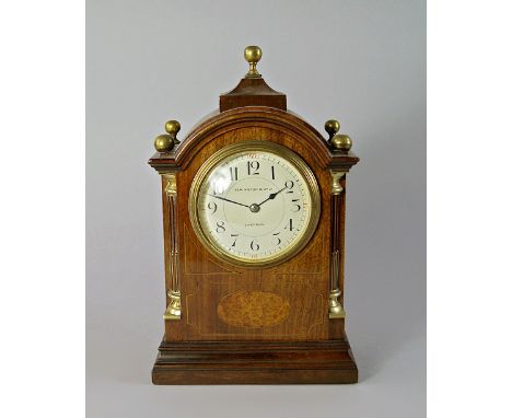 An Edwardian Elkington and Company mahogany and line inlaid mantel clock, the case with arched top with ball finials, on a st