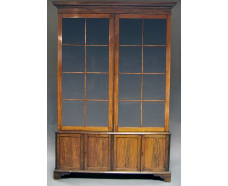 A rosewood book case, 19th century, with cushion moulded cornice, above two rectangular glazed doors enclosing shelves, on a 