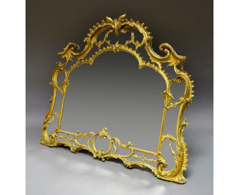 A large and impressive Chippendale style carved gilt wood over mantle mirror, 19th century, the shaped oval mirror with conti
