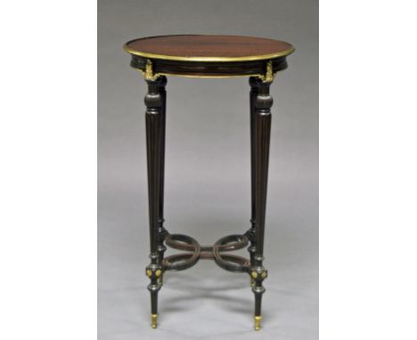 A French circular mahogany side table, late 19th/early 20th century,  the top with gilt metal rim, fluted tapered supports wi