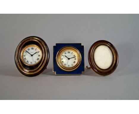 A Cartier gilt metal and brown enamel boudoir alarm clock and matching photograph fame, the clock of oval form with white dia