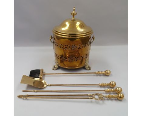 A cylindrical brass coal bucket and lid, 20th century, with ring handles, the body with pierced decoration, on lions paw feet