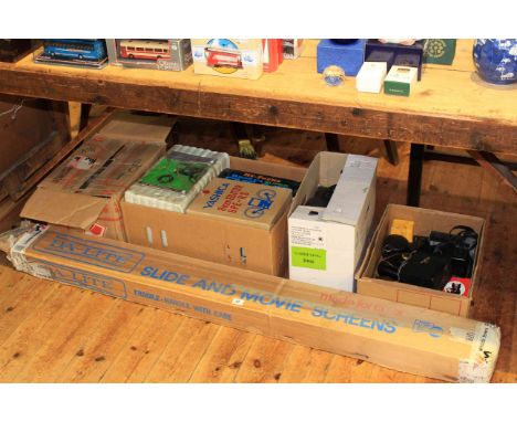 Collection of vintage photographic equipment including projector and screen