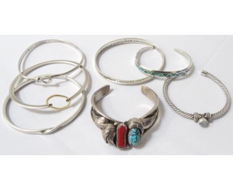 SELECTION OF SEVEN SILVER BANGLESof various sizes and designs, including stone and enamel set examples (7)