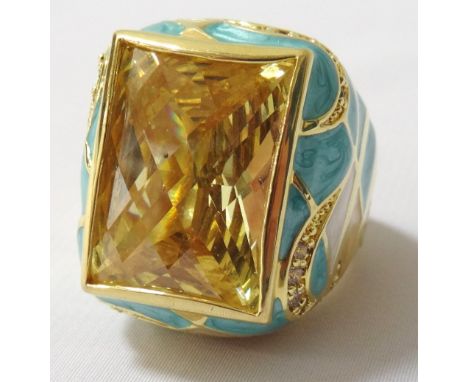 LARGE ENAMEL AND FACETED GLASS DRESS RINGthe central citrine coloured glass flanked by profuse enamel decoration to the setti