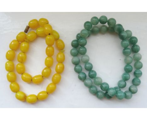 TWO BEAD NECKLACEScomprising a jade coloured hardstone example and an amber coloured example with screw clasp (2)