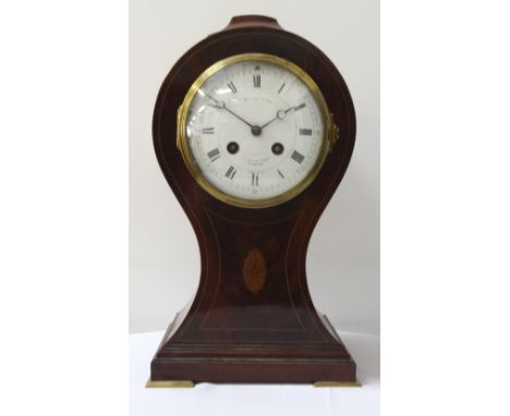 MAHOGANY AND INLAID SHAPED MANTLE CLOCKwith a circular enamel dial with Roman numerals and a French eight day movement, the d