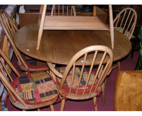 A Retro Ercol drop-leaf dining table with the matching set of six stickback chairs 