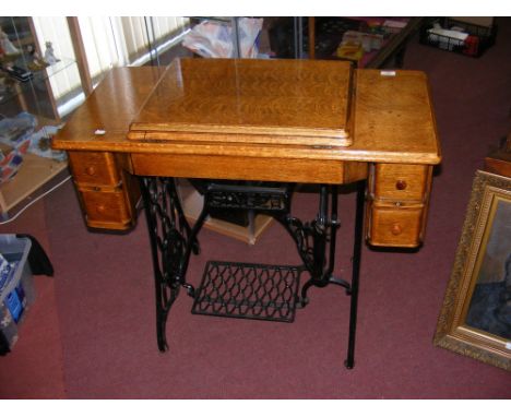 An antique Singer treadle sewing machine in oak surround