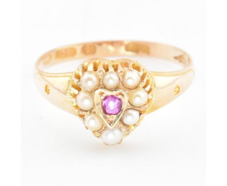 A Victorian hallmarked 15ct gold, ruby and pearl heart ring. The ring set with a central round cut ruby surrounded by a halo 