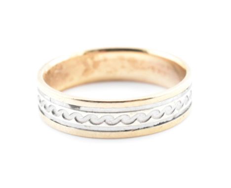 A hallmarked 9ct gold two-tone engraved band ring. The hallmarked 9ct yellow band ring having a central white gold section en